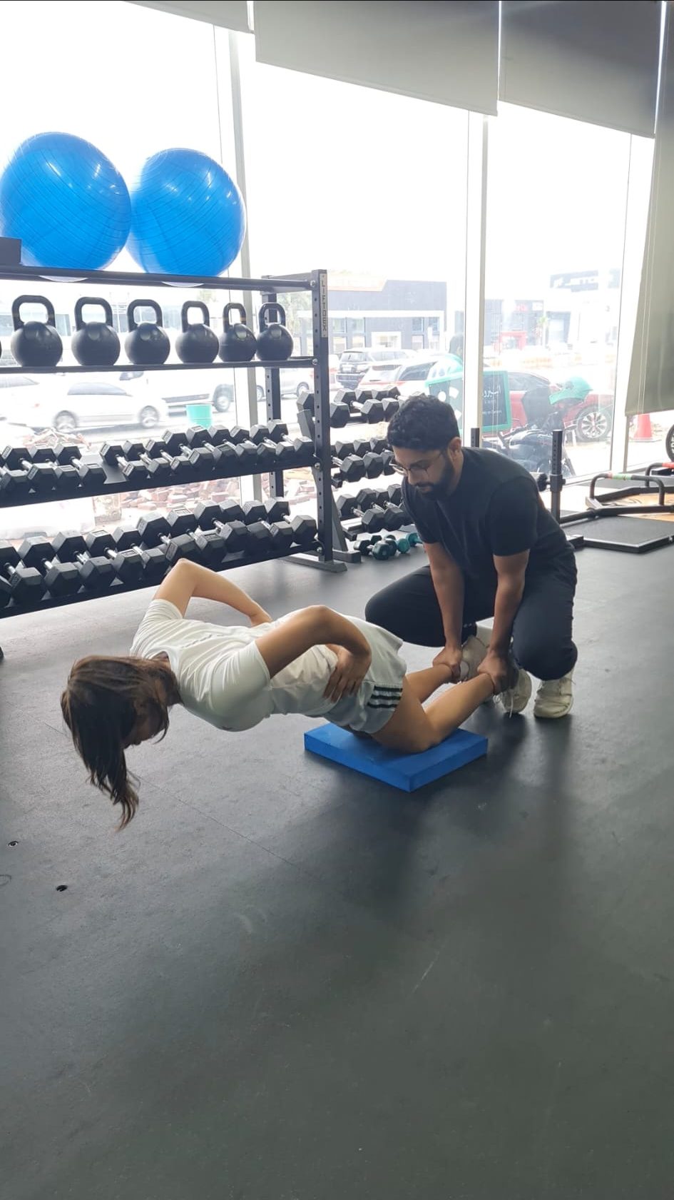 Coach Yasser guiding a young athlete through a Nordic hamstring curl
